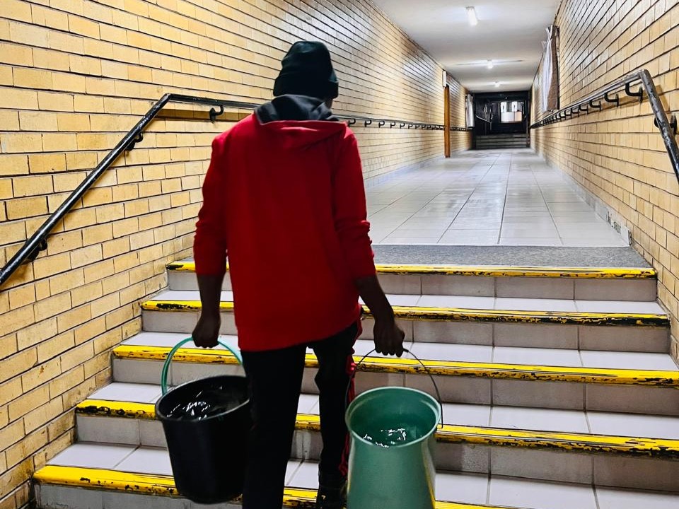 An employee at the Johannesburg Society for the Blind delivers hot water to the blind residents. Photo supplied by JSB